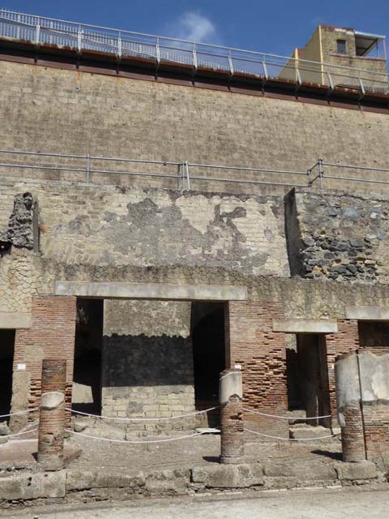 Decumanus Maximus, Herculaneum, July 2015. Building on north side of the Decumanus Maximus, doorway numbered 8, on left, and upper floor above.
Doorway with steps at number 9, is on the right. Photo courtesy of Michael Binns.