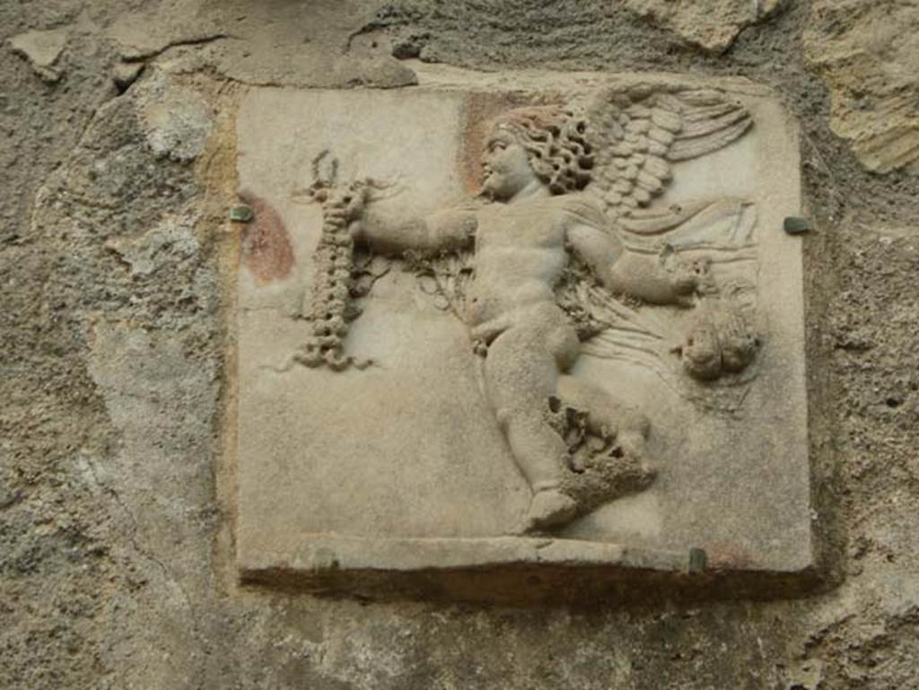 III.3 Herculaneum. June 2014. Detail of marble relief of cupid on wall above the pool. Photo courtesy of Michael Binns.