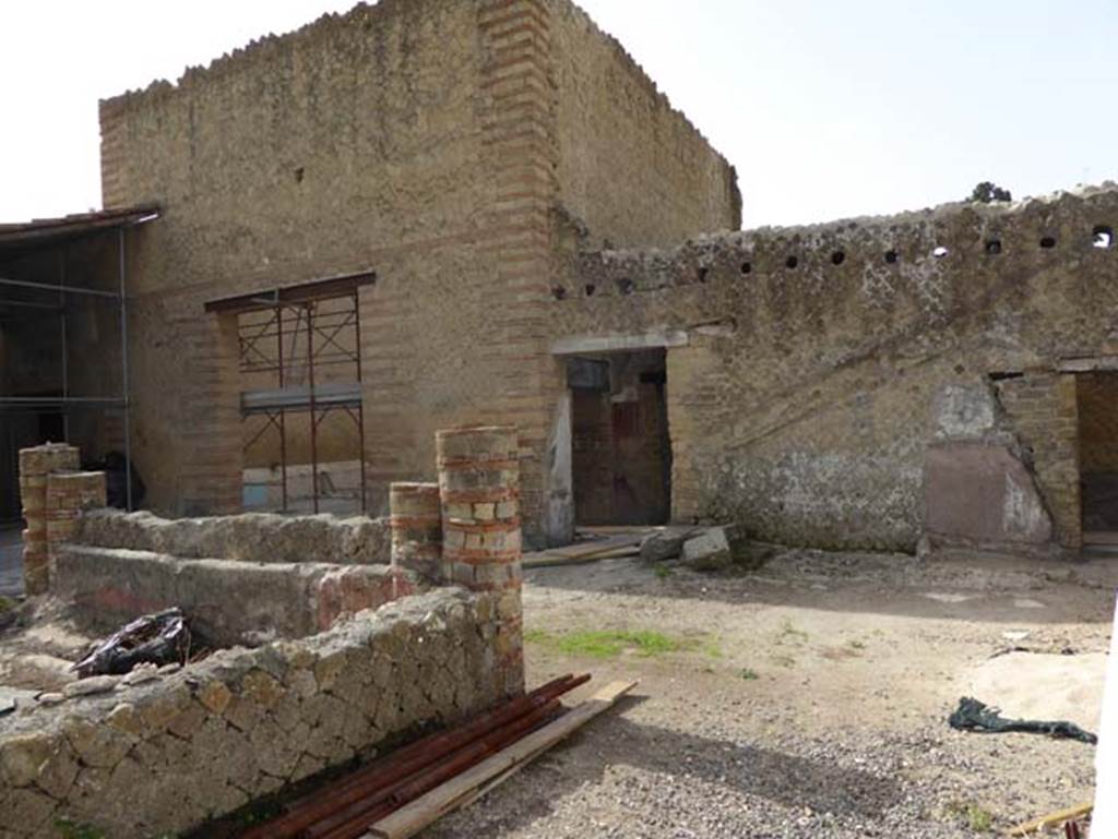 IV.1/2 Herculaneum, October 2014. South side of peristyle. Photo courtesy of Michael Binns.
Between the two doors, on the right, the imprint on the wall marks the site of a wooden stairs with stone base.
The carbonised wooden stairway has now completely disintegrated. 

