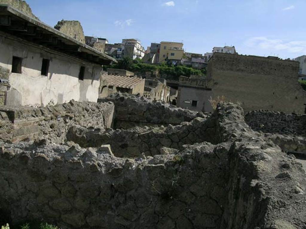 IV.3/4, Herculaneum, May 2005. 
Upper floor, looking north towards III.11 (white building, on left), and fullonica at IV.5/6/7, centre. 
Photo courtesy of Nicolas Monteix.
According to Monteix, on the west side of the upper floor were three rectangular tubs/basins used as an attic granary.
Found: 30th November 1928, at the back of the wall was found a rectangular tub/basin 2.09m long, by 1.54m wide, with a depth of 0.86m.
In it was a deposit of cereals, grain, inventory no.378.
Found: 8th January 1929, the two tubs placed to the north of the already described on 30th November have been excavated. 
The second was 2.10m long, 1.50m wide, and 0.85 deep. The walls were completely covered with plaster. The base was of cocciopesto and reasonably conserved. No objects were found.
The third was 2.10m long, 1.80m wide, and 0.85m deep. No objects
See Monteix, N. 2008. La conservation des denres dans lespace domestique  Pompi et Herculanum, MEFRA 120-1, p. 131.

