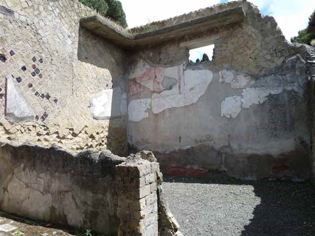 IV.8, Herculaneum, May 2010. Looking towards north-east corner of room at eastern end of corridor. According to Maiuri – 
“The last spacious room at the back has a beautiful motif in the IV style painted on the upper part of the wall, of draped curtains disclosing an architectural view”.
See Maiuri, A. (1977). Herculaneum, (no.53 of the Guide-Books to the Museums, Galleries and Monuments of Italy), (p.31).
