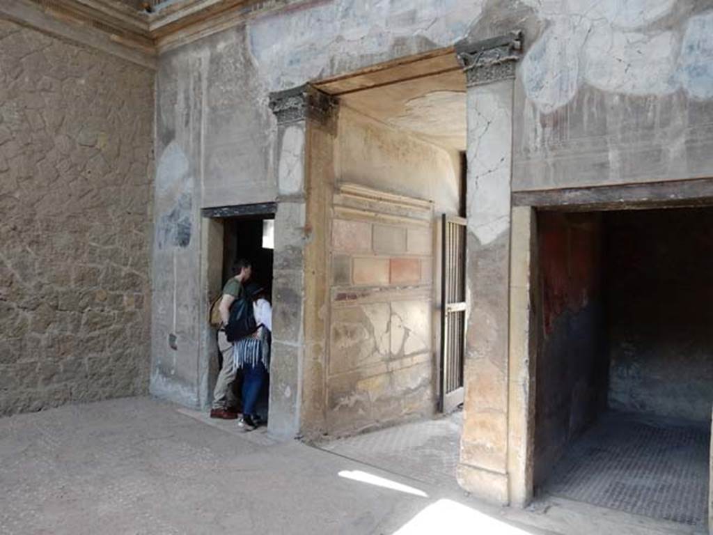 V.1 Herculaneum, May 2018. Looking towards south-west corner of atrium, with doorway to room 3, on left.
The entrance corridor is in the centre, and doorway to room 2, on right. Photo courtesy of Buzz Ferebee.

