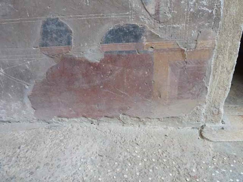 V.1 Herculaneum. May 2010. North wall of atrium, painted zoccolo (lower plinth or dado) on west side of doorway to room 4.