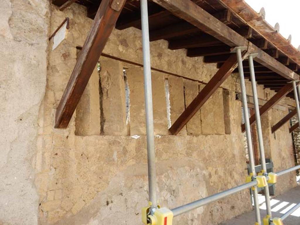 V.4 Herculaneum. May 2018. Looking south along north end of façade, with marble plaque in position on boundary.
Photo courtesy of Buzz Ferebee.