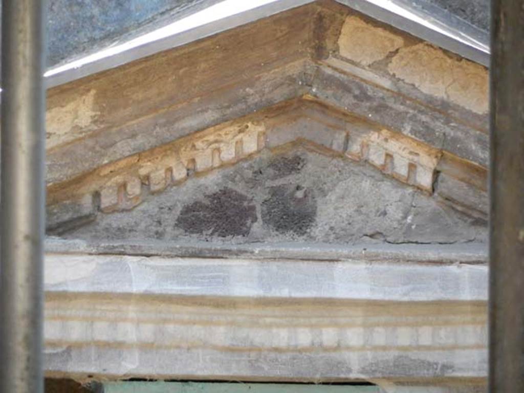 V.5 Herculaneum, May 2018. Detail of pediment of aedicula shrine.  Photo courtesy of Buzz Ferebee.

