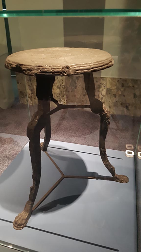 V.5 Herculaneum. August 2023
Carbonised wooden table with clawed legs, found in the room with three windows overlooking courtyard.
On display in exhibition entitled – “Materia. Il legno che non bruciò ad Ercolano”.  Photo courtesy of Maribel Velasco.
