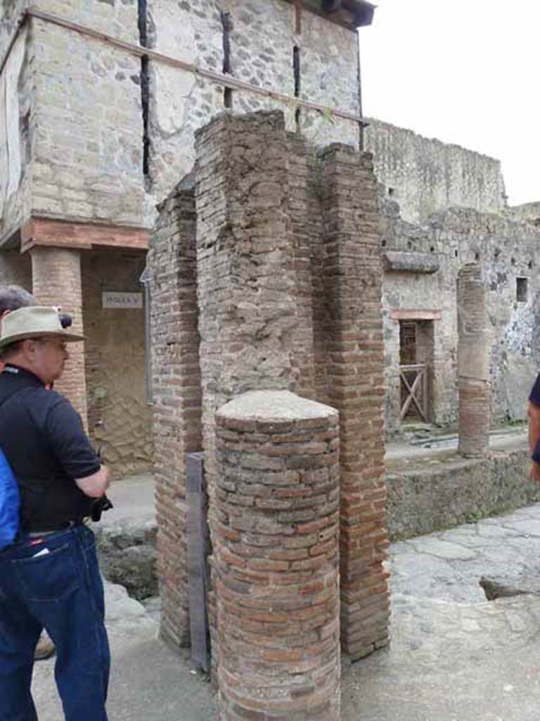Ins. V. May 2010. Looking east across junction of Cardo IV Superiore, towards Ins. V from rear of the water tower. Doorway at V.9 can be seen on the right of the water tower, in the centre.
