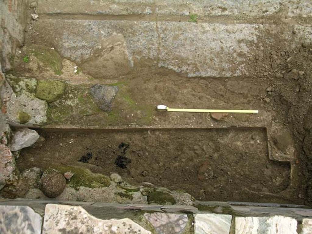 V.10, Herculaneum. December 2004. Drain, or pit, on north side of counter in shop-room. Photo courtesy of Nicolas Monteix.