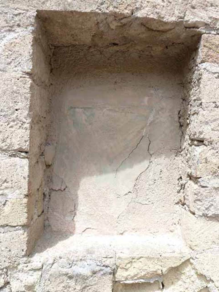V. 10, Herculaneum, May 2010. Niche in west wall of shop-room.
