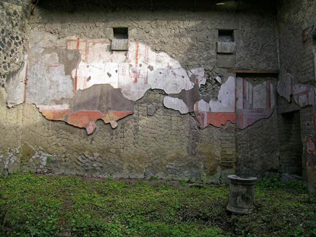 V.11, Herculaneum. May 2004. Looking towards east wall of atrium. Photo courtesy of Nicolas Monteix.
According to Maiuri, this atrium showed the rare detail of the proof of the height of the compluvium.
Still preserved simmetrically on both the east and west walls, were the large square holes for the heavy support beams of the roof.
Below these holes protrude square blocks of tufa forming a small shelf for each hole, to better support the weight of the two heavy beams, they almost formed a cubic capital by crowning the four pillars clamped in the wall to strengthen the weight of the compluvium.