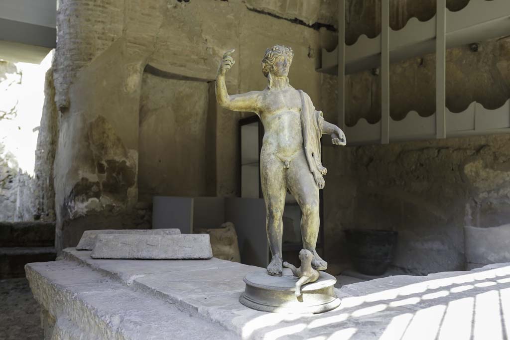 VI.12 Herculaneum. August 2021. Reproduction bronze statuette of Bacchus on shop-counter. Photo courtesy of Robert Hanson. 