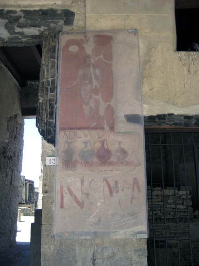 VI.13 Herculaneum on left, VI.14 on right. June 2011. 
Painted sign on pilaster between house entrance and shop. Looking south.
Photo courtesy of Sera Baker.
