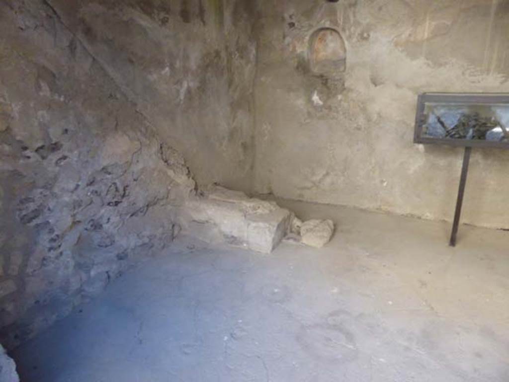 VI 15 Herculaneum, September 2015. Base of stairs near south-east corner.
According to Guidobaldi, in the south-east corner was a well to draw water from the cistern fed by the impluvium of the Casa del Salone nero, which would exclude the existence of a separate property, and as such this shop originally would have been a room in part of that house. 
See Guidobaldi, M.P, 2009: Ercolano, guida agli scavi. Naples, Electa Napoli, (p.104 of p.103-107).

