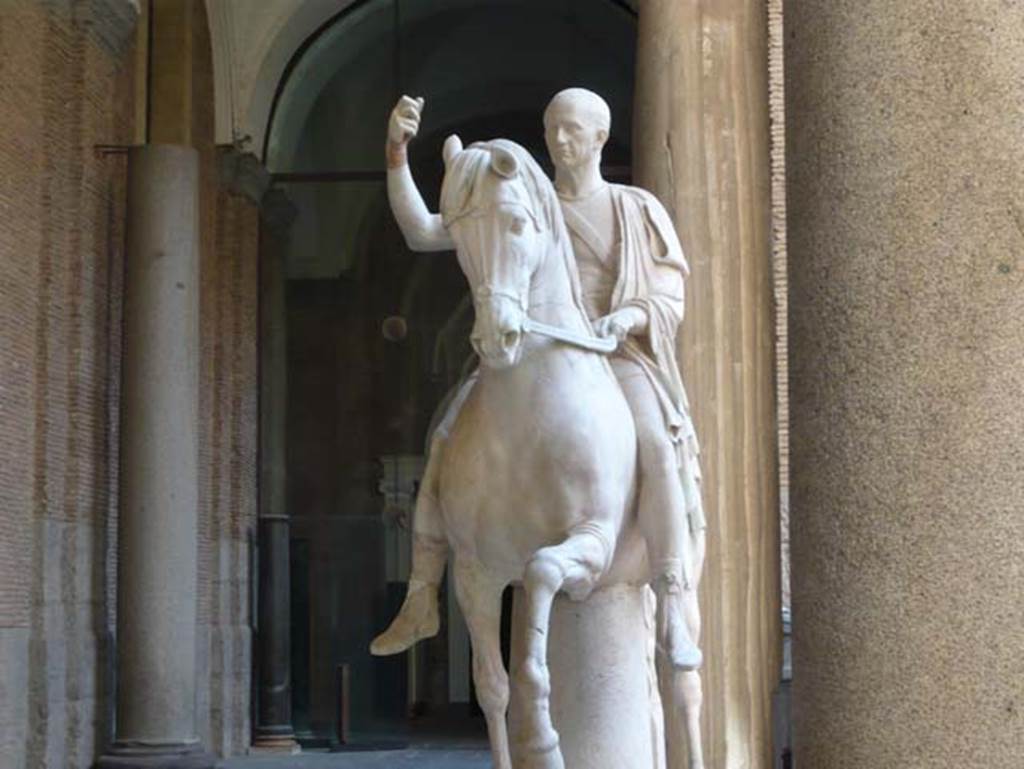VII.16 Herculaneum. May 2010. Equestrian statue of the elder M. Nonius Balbus.
Now in Naples Archaeological Museum. Inventory number 6211.
Photo courtesy of Buzz Ferebee.
According to the information board in the Palazzo Reale at Portici in 2015, the statue was found in 1746 and was in pieces and headless. The sculpture was believed to depict Balbus the Younger’s father. Hence, during restoration, Canart made head for it after a portrait certainly showing Balbus senior, in compliance with the principles of Classicism, which called for full restoration of mutilated sculptures. Actually the two statues are believed to portray the same individual, being honoured respectively, by the towns of Nuceria and Herculaneum.

