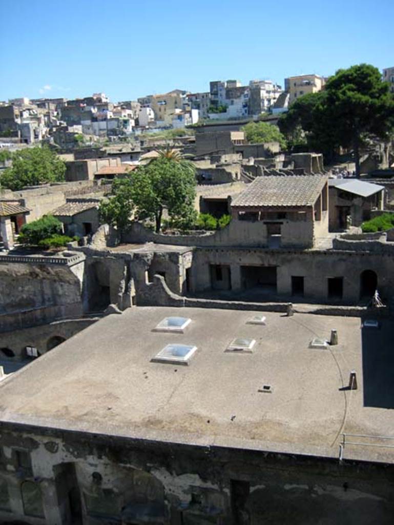 Ins. Orientalis I, 1a, Herculaneum, June 2011. Looking north from access roadway.
Photo courtesy of Sera Baker.
The roof of the Suburban Baths can be seen, lower centre.
Above the roof is the terrace with rooms opening onto it, which now form the House of M. Pilius Primigenius Granianus.
The upper rooms above the terrace are now part of the House of the Gem.