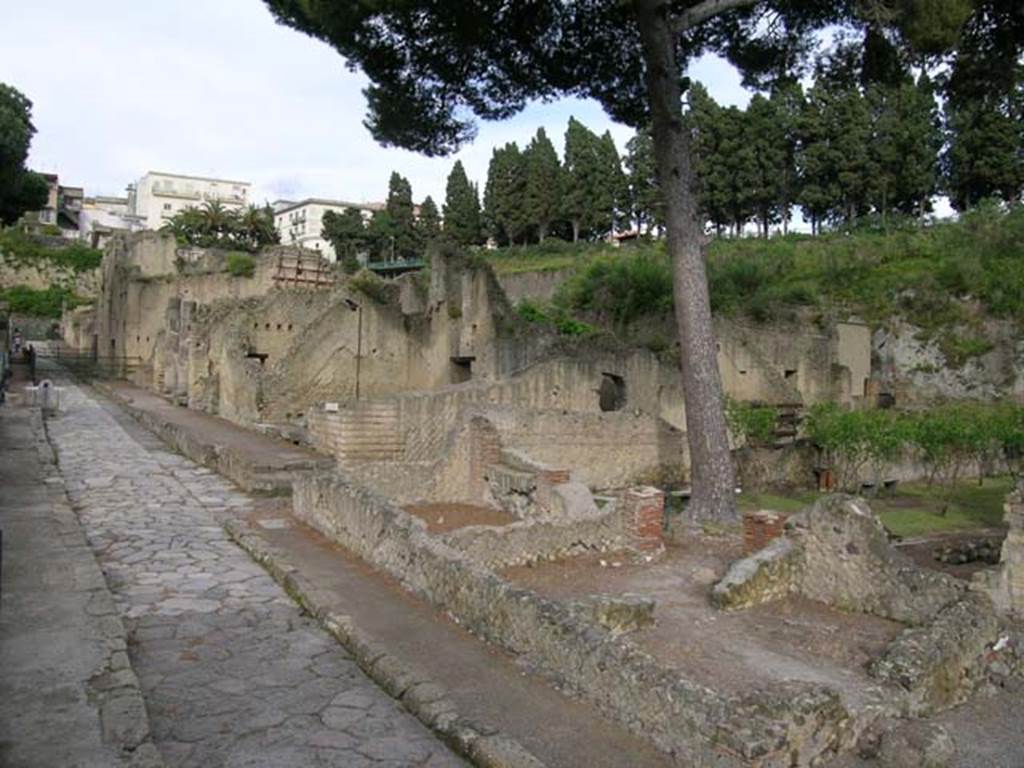 Ins. Orientalis I.3, Herculaneum, May 2004.
Looking towards area of house and garden of Telephus Relief on its north-western side, lower centre right.
The aedicula lararium can be seen against the north wall of the garden area.
This rustic area occupied all the area on the north side of the house.
In the centre of the photo, would be the area of room C, on its south side would be room A, with a doorway into room B on its south side.
Room D with the three stoves, is on the extreme right, behind room B. On the left is Cardo V, looking north.
Photo courtesy of Nicolas Monteix.
The rustic area was composed of a stable with ramp, and a garden, with some rooms on the south and west sides.
These rooms may have been turned into a commercial use, during their last days.
In one of the rooms, (room B), the floor was completely covered with tiles, as often seen in a workshop of a laundry.
In another, (room D), a set-up of three stoves would probably have been used for the industry carried out in workshop B.