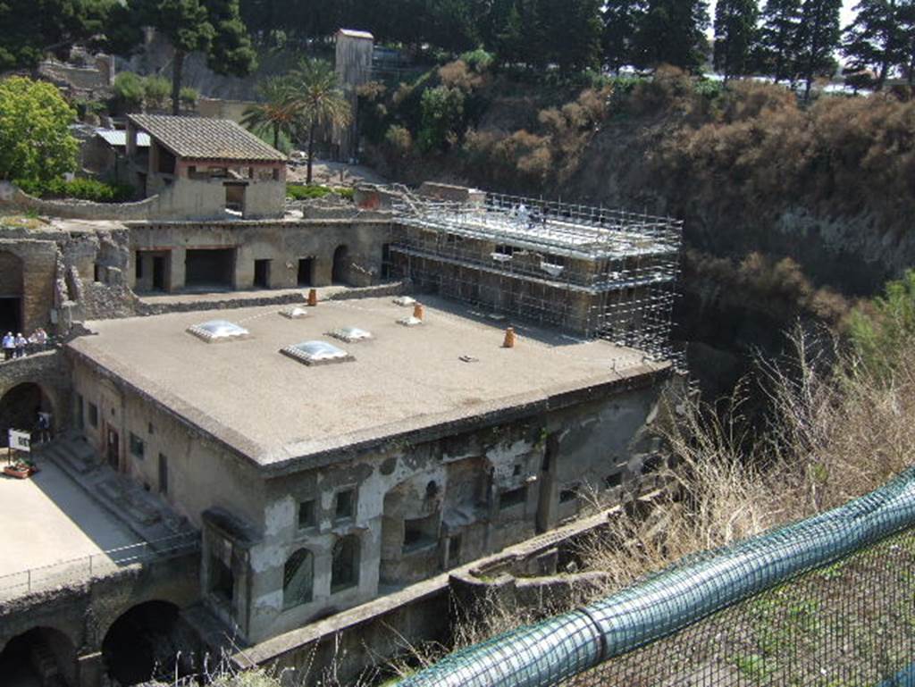 Herculaneum, May 2006. Looking north-east from roadway towards Suburban Baths, centre, and House of the Telephus Relief, top right with scaffolding. Above the roof of the baths, the House of the Gem can be seen. The lower floor, with doorways onto a loggia, belonged to the House of M. Pilius Primigenius Granianus.
