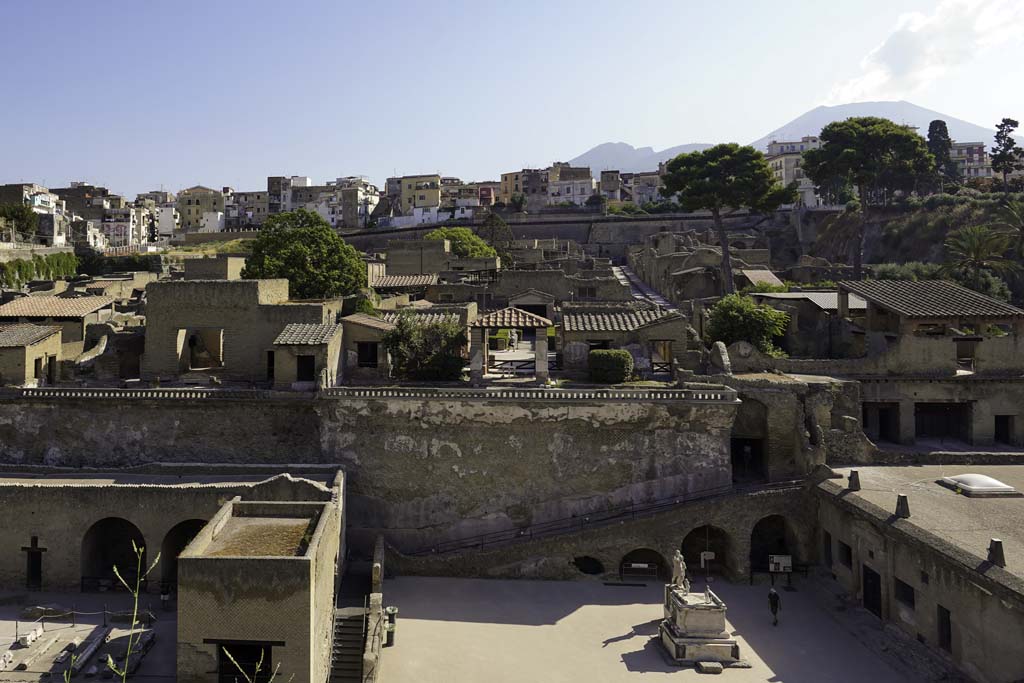 Herculaneum, August 2021. 
Looking north from entrance roadway towards rear of the House of the Stags, (Ins IV.21), above the Terrace of Balbus, in centre.
Vesuvius is towering in the background. Photo courtesy of Robert Hanson.

