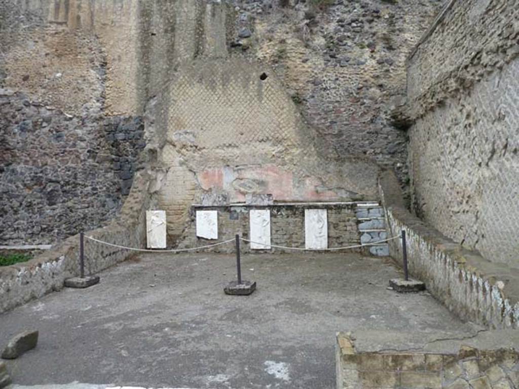 Herculaneum, September 2015. Sacred Area terrace, looking north in the shrine of the Four Gods. The copies of the reliefs are thought to be hanging in their original position, fastened to the front wall of the podium. The originals, now in Naples Museum, were recently found on the ancient beachfront, no doubt thrown there by the force of the eruption, and show Minerva, Neptune, Mercury and Vulcan.