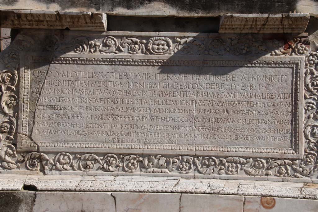 Herculaneum, October 2020. Inscription on memorial altar to Marcus Nonius Balbus. Photo courtesy of Klaus Heese.
According to the Epigraphic Database Roma this reads

Quod M(arcus) Ofillius Celer IIvir iter(um) v(erba) f(ecit) pertinere at municipi
dignitatem meritis M(arci) Noni Balbi respondere d(e) e(a) r(e) i(ta) c(ensuerunt):
Qum M(arcus) Nonius Balbus quo hac vixerit parentis animum cum plurima liberalitate
singulis universisque praistiterit placere decurionibus statuam equestrem ei poni quam
celeberrimo loco ex pecunia publica inscribique M(arco) Nonio M(arci) f(ilio) Men(enia) Balbo pr〚a〛(etori) pro co(n)s(uli) patrono universus 
ordo populi Herculaniessis ob merita eius item eo loco quo cineres eius conlecti sunt aram
marmoream fieri et constitui inscribique publice M(arco) Nonio M(arci) f(ilio) Balbo exque eo loco parentalibu(s)
pompam duci ludisque gymnicìs quì solitì eran̂t fierì diem adicì unum in honorem eius et cum in theatro
ludi fient sellam eius ponì. C(ensuerunt).

Cooley shows the following:
Seeing as Marcus Ofillius Celer, duumvir for the second time, made the statement that it was conducive to the town’s dignity to act in response to the public service of Marcus Nonius Balbus, they decreed on this matter as follows: Marcus Nonius Balbus, for as long as he lived here, displayed a father’s spirit together with the utmost generosity to individuals and everyone alike. Therefore it pleases the town councillors that an equestrian statue be set up to him in the most frequented place out of public funds and that it be inscribed: ‘To Marcus Nonius Balbus, son of Marcus, of the Menenian voting-tribe, praetor, proconsul, patron. The whole governing body of the people of Herculaneum (set this up) on account of his public service’; and also in the same place, where his ashes have been gathered together, that a marble altar be made and set up and publicly inscribed: ‘To Marcus Nonius Balbus, son of Marcus’; and that a procession proceed from this place at the festival of the dead, and that one day be added in his honour to the athletic games, which had usually occurred, and that when shows are performed in the theatre, his seat be placed there. They decreed.
[AE (1976) 144]
See Cooley, A. and M.G.L., 2014. Pompeii and Herculaneum: A Sourcebook. London: Routledge, F104, p. 191.
