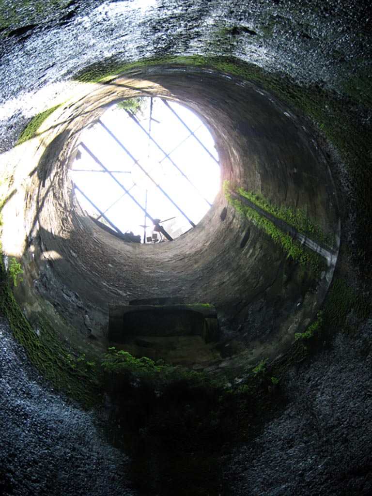 Herculaneum Theatre, July 2009.
The eighteenth-century access shaft to the theatre. Photo courtesy of Sera Baker.
“From the lower vestibule a flight of 72 steps cut into the tufa bank leads down to the upper part of the theatre (summa cavea), recognizable from the double flights of steps that descend to the great circular ambulacrum between the summa and the media cavea; the latter is traversable from one extremity to the other, where there are stairs leading down to the level of the orchestra”…….
See Maiuri, A, (1977). Herculaneum, (p.73)