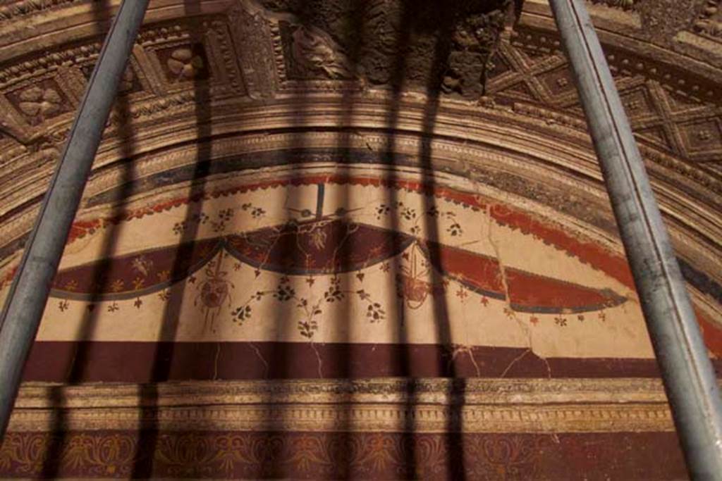 Villa dei Papiri, Herculaneum. July 2010. Room (I) on lower terrace. Upper south wall with a tambourine or rhyton and pan pipes hanging from crossed vegetal thyrsi.
Photo courtesy of Michael Binns.
See Esposito D. and Guidobaldi M., 2010. New Archaeological Research at the Villa of the Papyri, in the Villa of the Papyri at Herculaneum. Berlin: De Gruyter, p. 36.