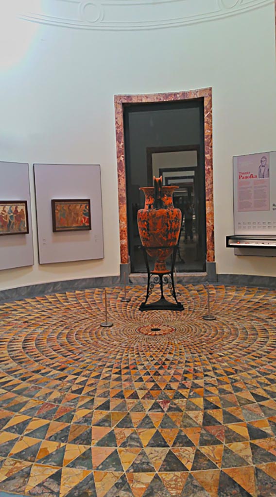 Villa dei Papiri, Herculaneum. July 2019.
Circular polychrome mosaic floor in room CXXXIX, from the Belvedere.
It is now installed in a circular room, part of the “Magna Grecia” collection of Naples Archaeological Museum.
Inventory number s. n. Photo courtesy of Giuseppe Ciaramella.
According to the description card in the Museum –
“Al II Complesso di Stabiae appartengono molti dei sectilia policromi, mentre da Ercolano proviene il meraviglioso pavimento circolare a file di triangoli concentrici, nella sala CXXXIX, rinvenuto nel 1751 nel cosiddetto Belvedere della Villa dei Papiri.”
(Many of the polychrome sectilia belong to the Second Complex at Stabia, while from Herculaneum comes the wonderful circular floor with rows of concentric triangles, in room CXXXIX, found in 1751 in the so-called Belvedere of the Villa of the Papiri).