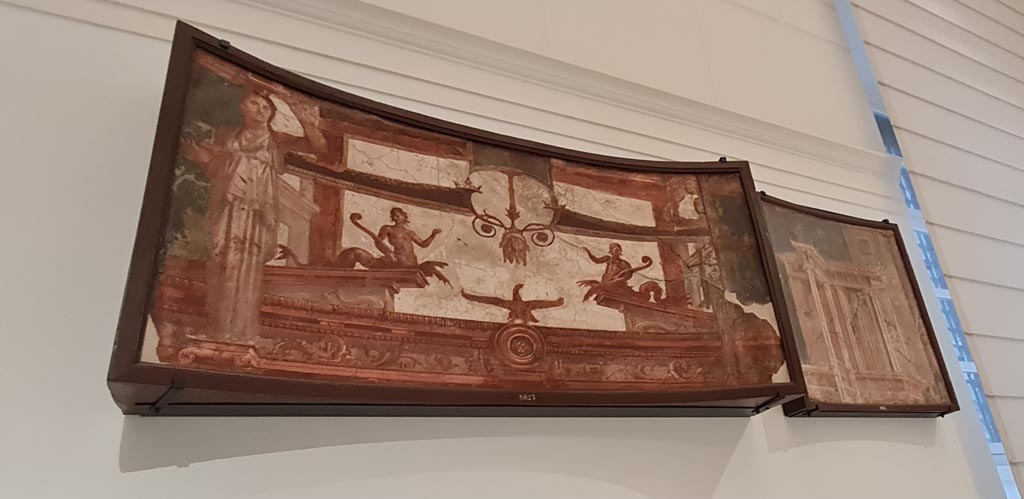 Herculaneum Augusteum. April 2023. 
No.1 on above descriptive card – Fastigium (upper panel) of a shrine with Caryatids, inv. 9825.
and
No.2 on above descriptive card – Building with window and colonnade shown in perspective, inv. 8534.
On display in “Campania Romana” gallery in Naples Archaeological Museum.  Photo courtesy of Giuseppe Ciaramella.
