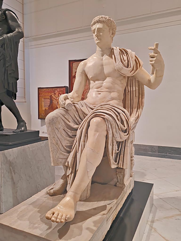 Herculaneum Augusteum. April 2023. 
Detail of white marble statue of Claudius, inv. 6056, with modern additions of the head and arms. 
Photo courtesy of Giuseppe Ciaramella.
