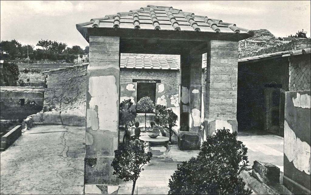 IV.21, Herculaneum. Undated postcard.
Looking west from garden terrace, across pergola 18, towards window belonging to diaeta 23, the small room overlooking garden terrace on west side. 
Photo courtesy of Peter Woods. 
