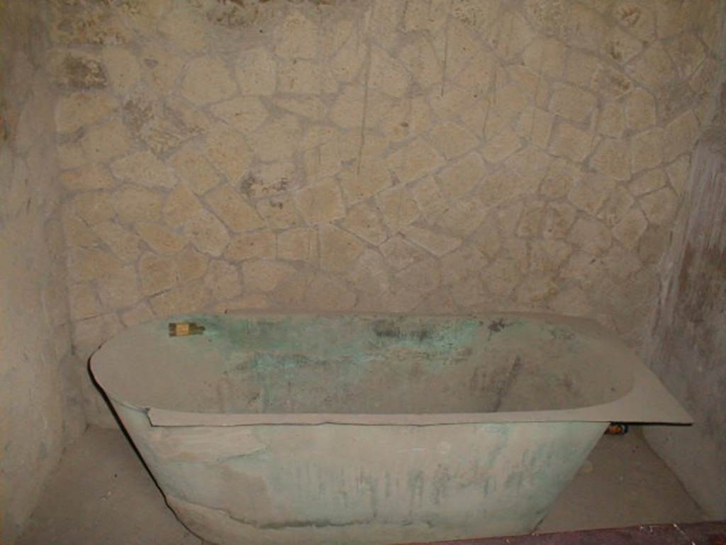 IV.21, Herculaneum.  May 2004. Bronze bathtub. According to Deiss found in this house was an unusual object, a bronze bathtub – unusual because most Romans favoured the public baths.  Also found were the normal objects: the uncut bread, the lamps, the glassware, the tiny statuettes, the kitchen weights, the bowls, the bells for calling servants, the perfume flasks, a necklace and a pair of dice.
See Deiss, J.J. (1968). Herculaneum, a city returns to the sun. London, The History Book Club, (p.43).
