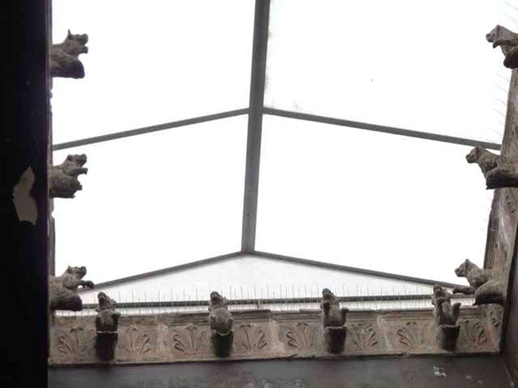 V.1 Herculaneum. May 2010. Detail of the compluvium in roof of atrium, showing terracotta water-spouts in the shape of dog’s heads. 