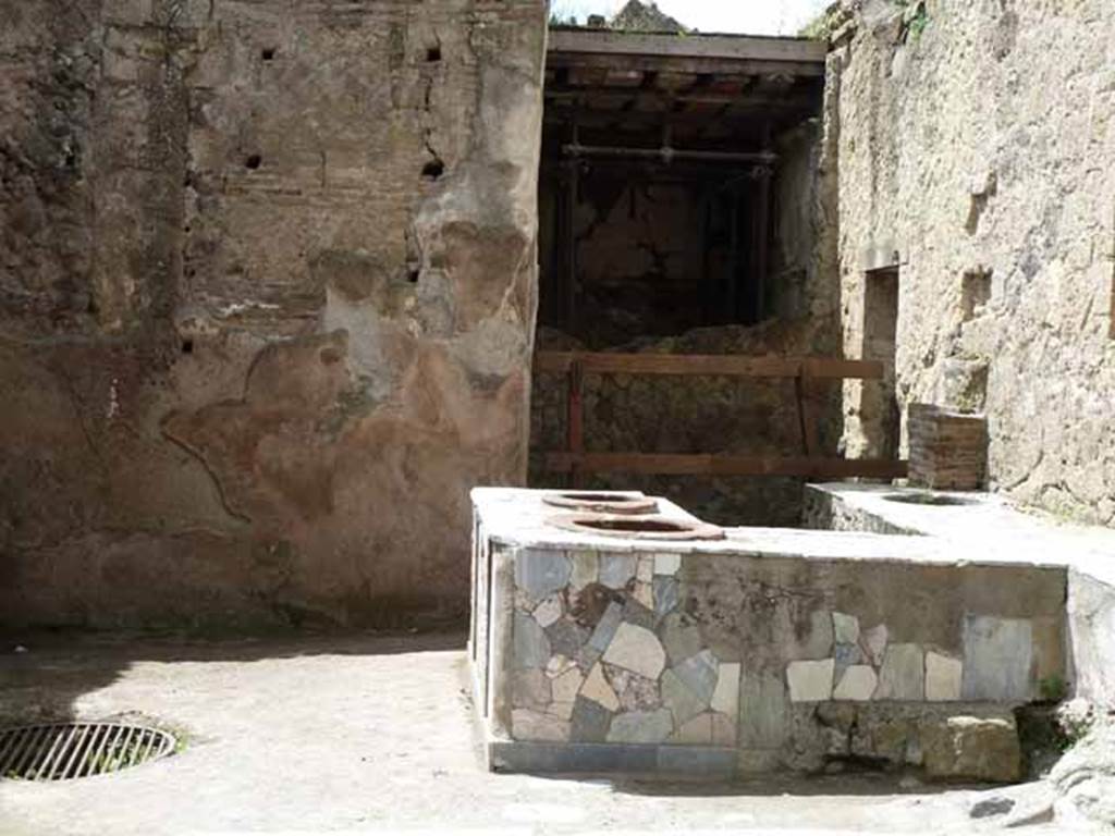 V. 10. Herculaneum, May 2010. Looking south-west across counter towards west wall of shop-room. 