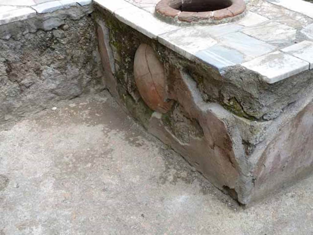 V. 10, Herculaneum, May 2010. West interior side of east arm of counter with large bulging dolium set into the counter, looking north-east.

 
