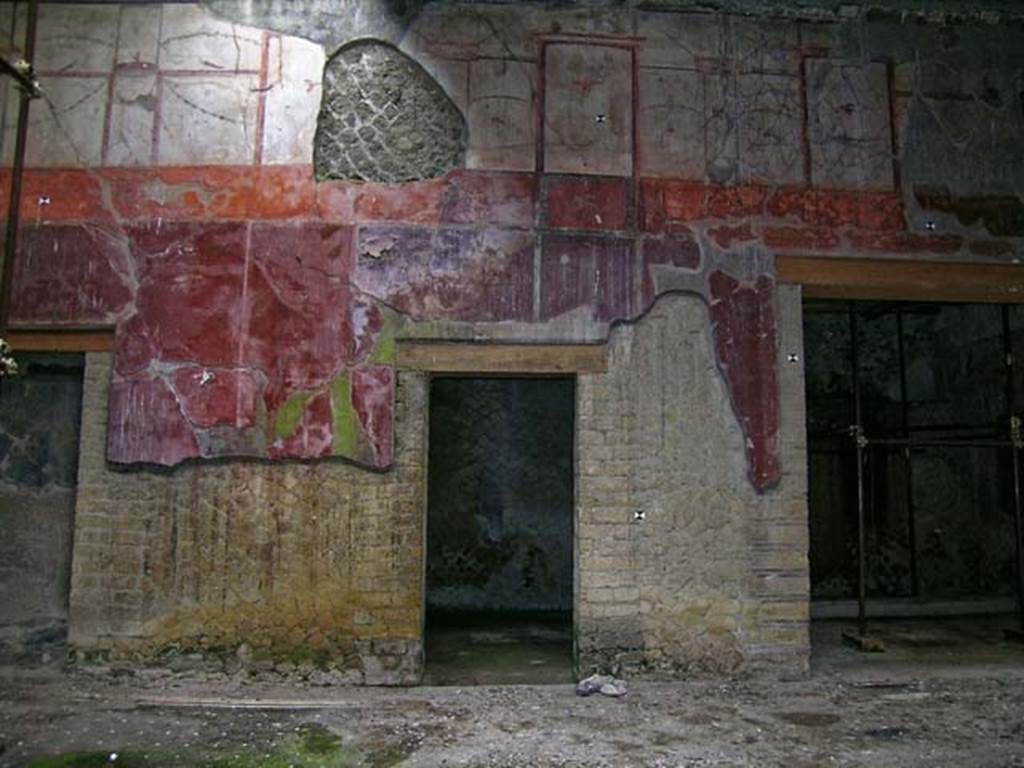 V.15 Herculaneum. May 2004. East side of atrium with room in centre and doorway to east ala, on right. Photo courtesy of Nicolas Monteix.
Maiuri described this central room as having � 
�fine decoration on white background with golden candelabra at the centre and animal motifs in the area of the paintings�.
