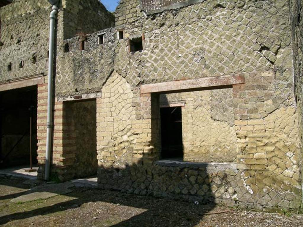 V.15, Herculaneum. May 2004. 
Looking north across east end of north portico towards doorways to tablinum, on left, and doorway and window of triclinium.
In the north wall of the triclinium is a doorway into the atrium, centre right. Photo courtesy of Nicolas Monteix.

