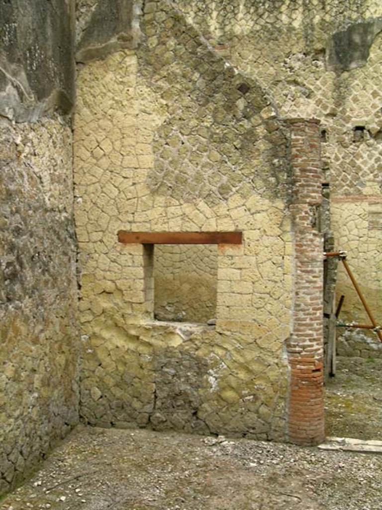 V.15, Herculaneum. May 2005. Large oecus at rear (south side) of garden area.
Looking towards south-west corner and west wall with window to cella penaria, and doorway from large oecus flanked by columns leading to windowed portico. Photo courtesy of Nicolas Monteix.
According to Maiuri, this room was flanked at the entrance by two semi-columns and with an airy window on the garden.
It was undoubtedly destined to be one of the most luxurious rooms of the house, but in its more recent times, it had passed to more rustic use. The remains of the walls are crude, and the floor is in coarse signino.
