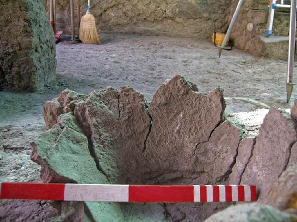 VI.12 Herculaneum. September 2004. Detail of crucible/melting pot. 
Looking east across shop-room, with corner of counter, in upper left. Photo courtesy of Nicolas Monteix.
