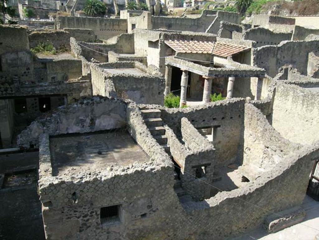 Ins.Or.II. 9/8, Herculaneum. May 2006. Looking west from upper floor of Palaestra block, above bakery, towards Insula V on Cardo V.
The doorway to V.31, Casa del Sacello di legno (House of the Wooden Lararium) is on the left, and V.30, Casa dell�Atrio corinzio (House of the Corinthian Atrium) is on the right. Photo courtesy of Nicolas Monteix.

