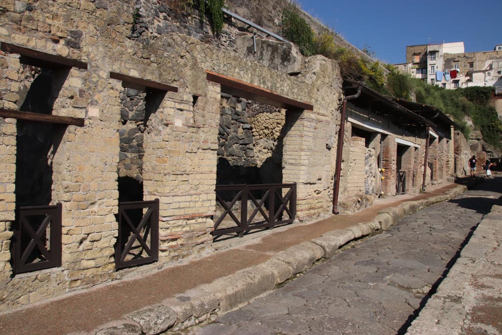 Cardo III Superiore, Herculaneum, October 2022. 
Looking north along west side with doorways at VII.5, on left, VII.6, VII.7, and continuing northwards to junction with Decumanus Maximus.
Photo courtesy of Klaus Heese.
