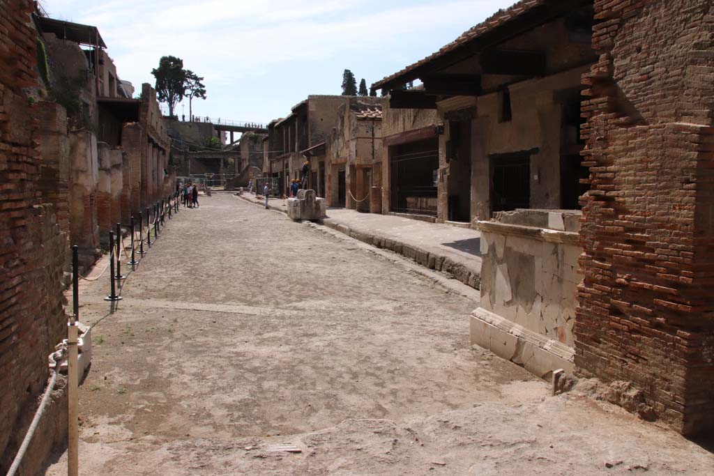Herculaneum, September 2019. Looking east along the Decumanus Maximus, from four-sided Arch. Photo courtesy of Klaus Heese.

In September 1961, Maiuri wrote “After a few weeks I found and finally opened the street of the Forum of Herculaneum and it seems to me that the city has regained its breath and found its natural centre of life........etc. A great roadway closed to carriages and beasts of burden, open only to pedestrians, with low and wide pavements/sidewalks, ample gutters for the disposal of water and a shady portico for walking in during the hot hours of the day and also offering a little cool air to us too. It was the large street of the ancient town that runs today, at a depth of 15 and more metres, parallel to the roads of present-day Resina.”
See Maiuri, A. (2008). Cronache degli scavi di Ercolano, 1927-1961, introduced by Mario Capasso. Sorrento, Franco Di Mauro Editore s.r.l., (p.117)
(“A distanza di poche settimane trovo finalmente aperto la vie del foro d’Ercolano e mi sembra che la citta abbia riacquistato il suo respire e ritrovato il suo naturale centro di vita…..etc. Una grande via chiusa ai carriaggi e alle bestie da soma, aperta solo al transito pedonale con larghi e bassi marciapiedi, capaci cunette per lo smaltimento delle acque e un portico ombroso da passeggiarvi nelle ore calde del giorno e da offrire presto anche a noi un po’ di frescura. Era il gran Corso della città antica che corre oggi, a 15 e più metri di profondità, parallelamente al Corso dell’ odierna Resina.”)

