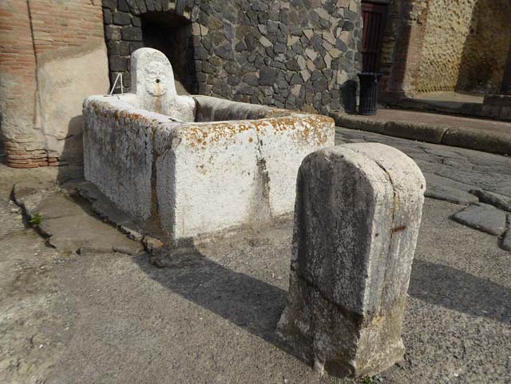 Decumanus Maximus, looking north-east towards fountain decorated with head of Hercules, from near east end of Ins. V.  October 2014. Photo courtesy of Michael Binns. 
